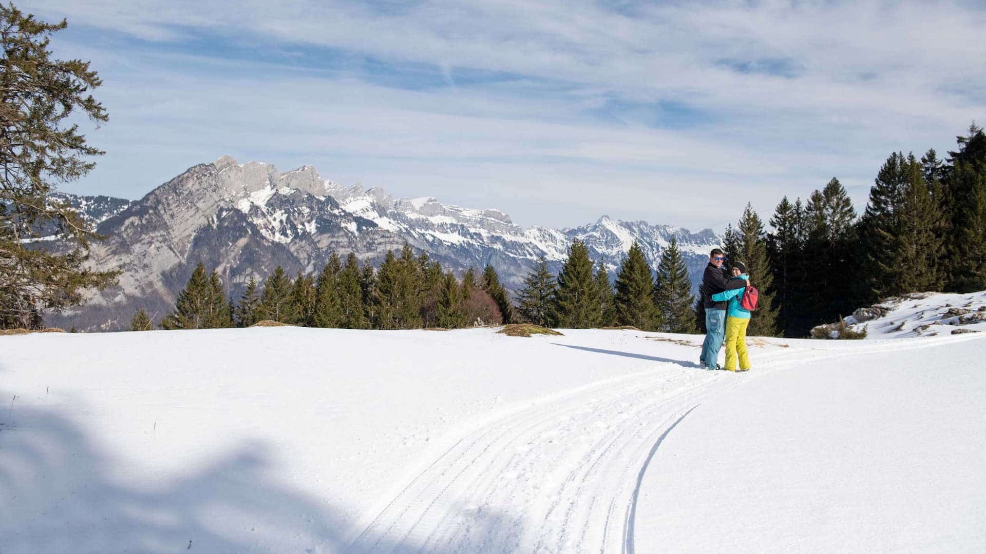 Eine Familie mit einem Kind auf der Skipiste beim Skifahren.