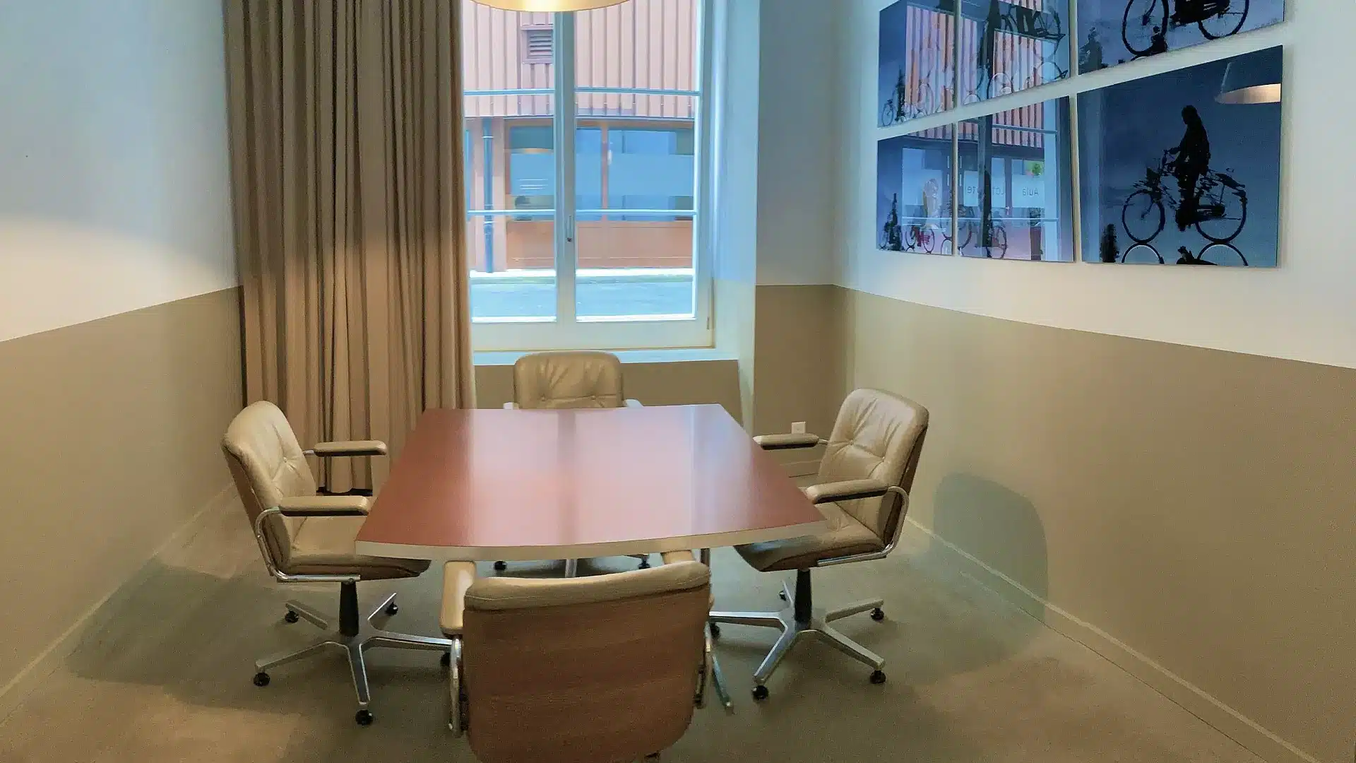 Kleiner roter Tisch mit vier Bürostühlen für Meeting oder Seminar.